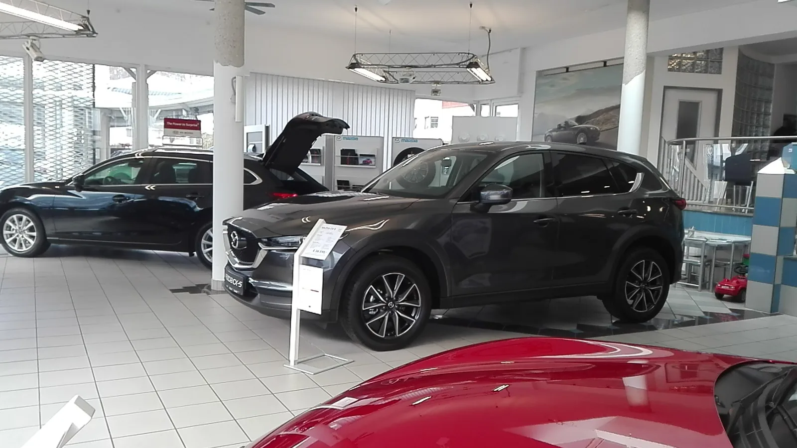 Schauraum mit einem dunkelgrauen Mazda CX-5 und einem blauen Mazda 6